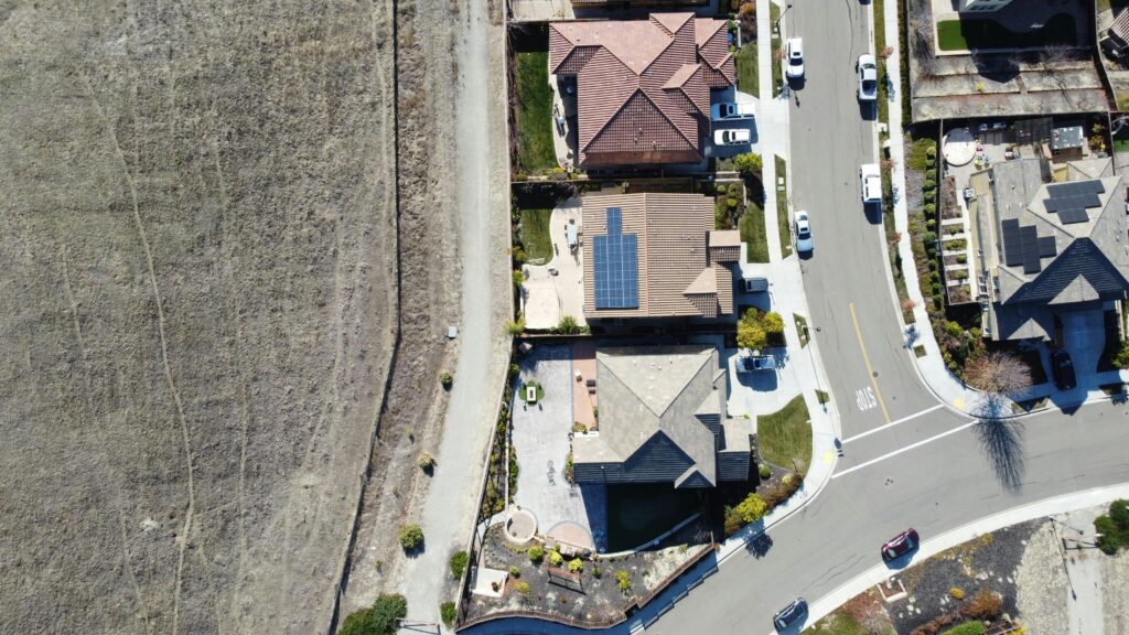 Top-down aerial view of a suburban neighborhood in Dublin, California with solar panels and parked cars.
