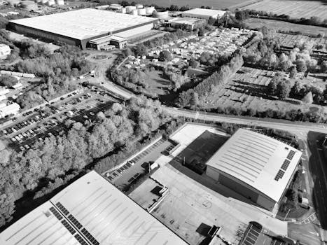 Black and white aerial photo of Hertfordshire industrial zone with warehouses and trees.
