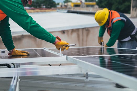 Workers secure solar panels on a rooftop, advancing renewable energy.