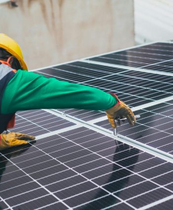 Technician installing solar panels on a rooftop for sustainable energy solutions.